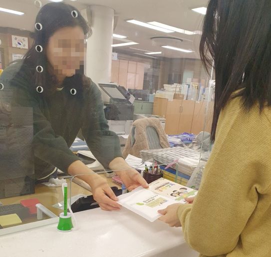 동 행정복지센터 직원이 긍정양육·홍보물품 리플렛을 배부하고 있다.