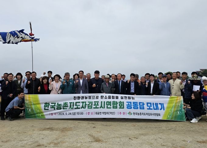 한국농촌지도자김포시연합회 공동답모내기 행사 참석자들이 기념촬영하고 있다.