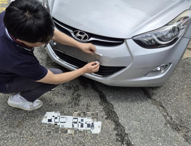 수원시 관계자가 체납차량의 번호판을 영치하고 있다.